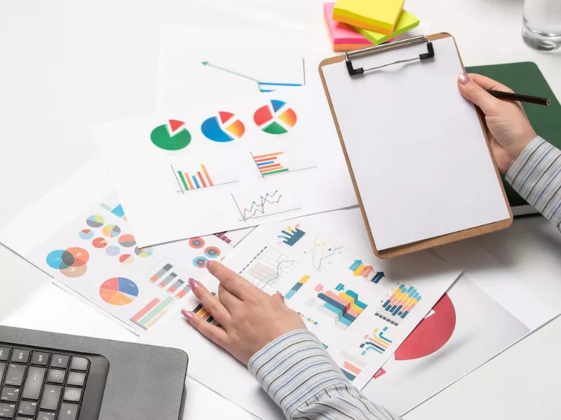 Analyst reviewing charts with a clipboard for KA02 report writing services preparation