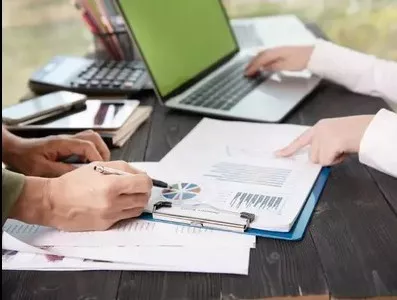 Professionals reviewing charts and data for KA02 report writing services documentation