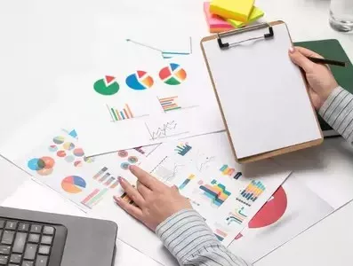 Analyst reviewing charts with a clipboard for KA02 report writing services preparation